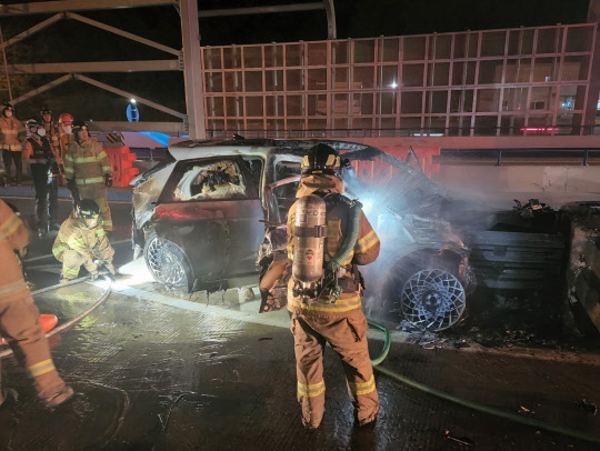 지난 4일 오후 11시께 부산 강서구 범방동 남해고속도로 제2지선 서부산요금소에 진입하던 승용차가 충격 흡수대를 들이받은 후 소방관들이 화재를 진압하고 있다. 연합뉴스